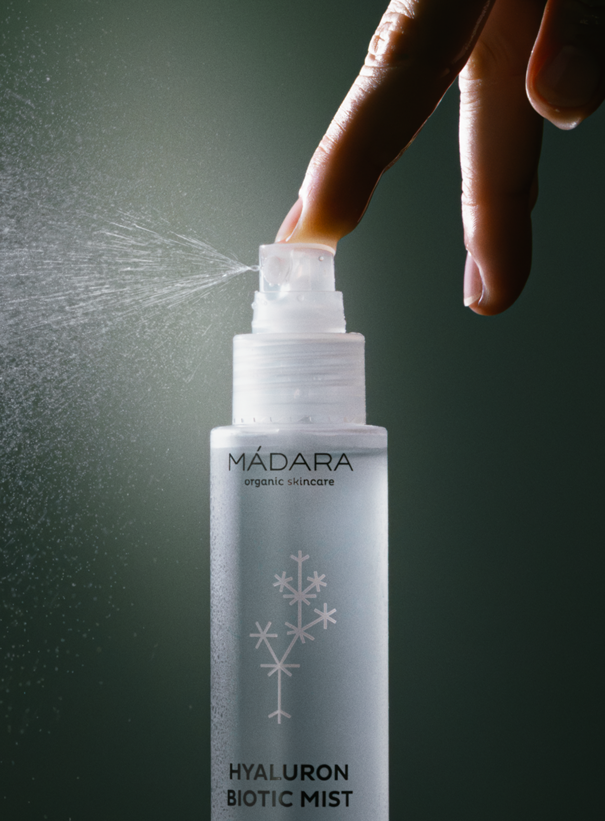Hand spraying MÁDARA Hyaluron Biotic Mist, showing fine hydrating mist for refreshing and moisturizing organic skincare