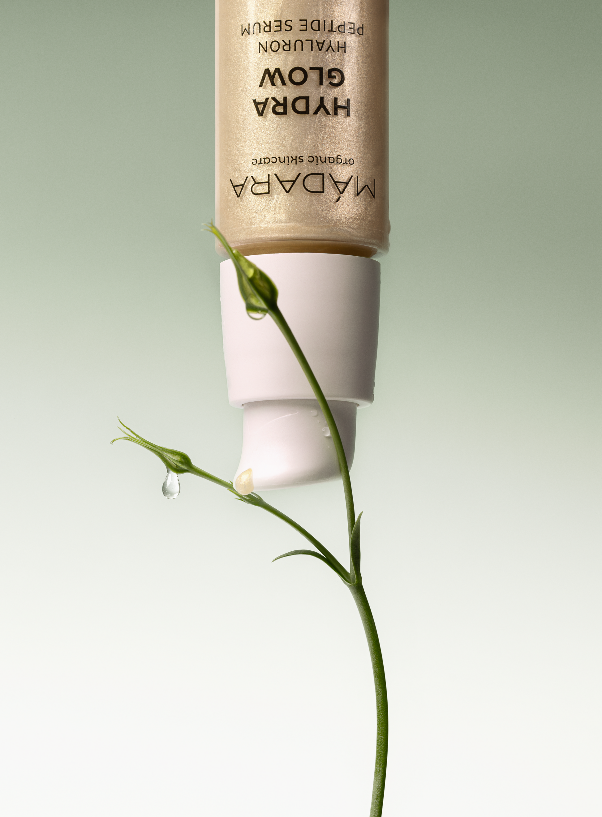 MÁDARA Hydra Glow Hyaluron Peptide Serum with golden formula and natural plant detail, highlighting hydration and radiance in organic skincare