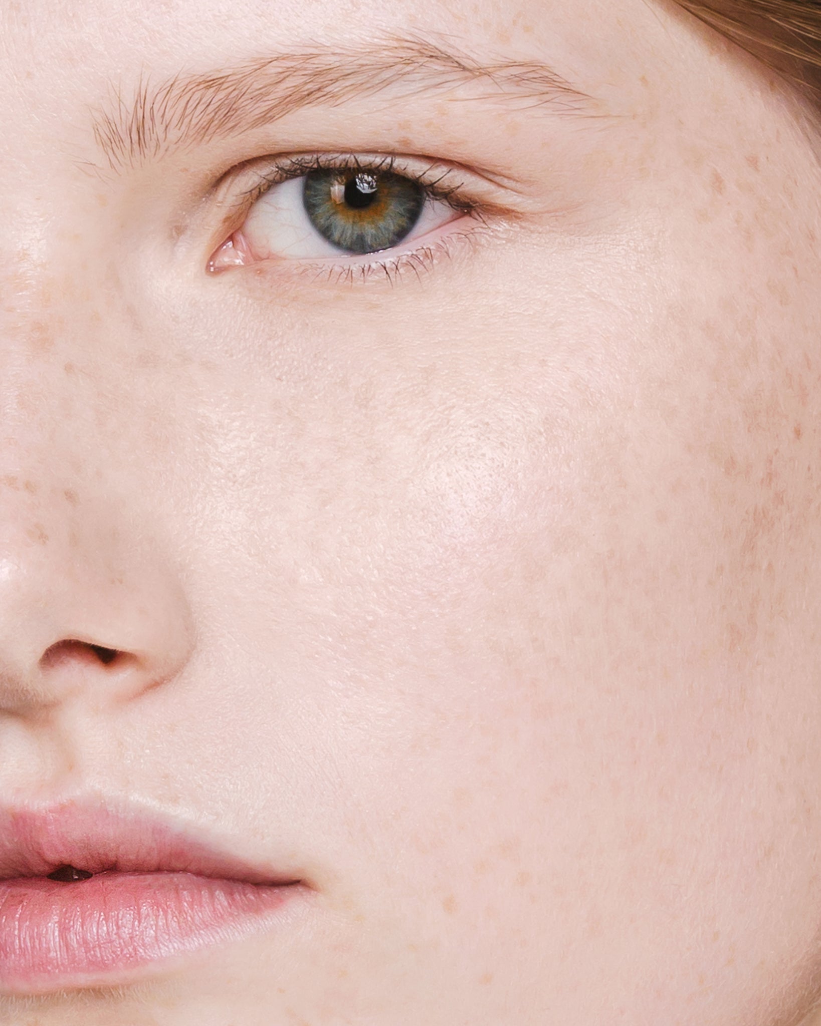 Model wearing MÁDARA Organic Skincare the concealer vanilla on A6100 concealer on skin; close-up portrait shows natural application results.